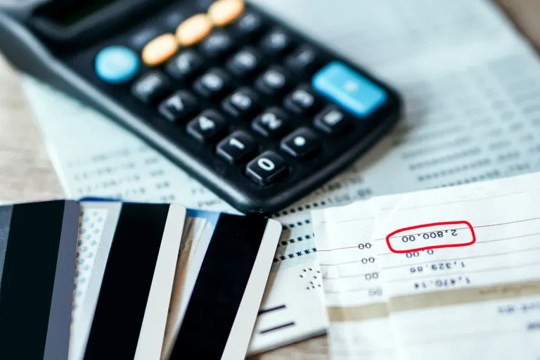A calculator on top of bills and credit cards